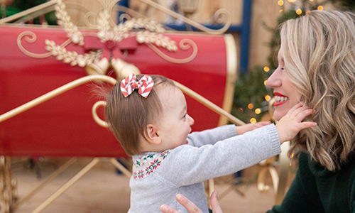 A child happy to see mom in front of sleigh